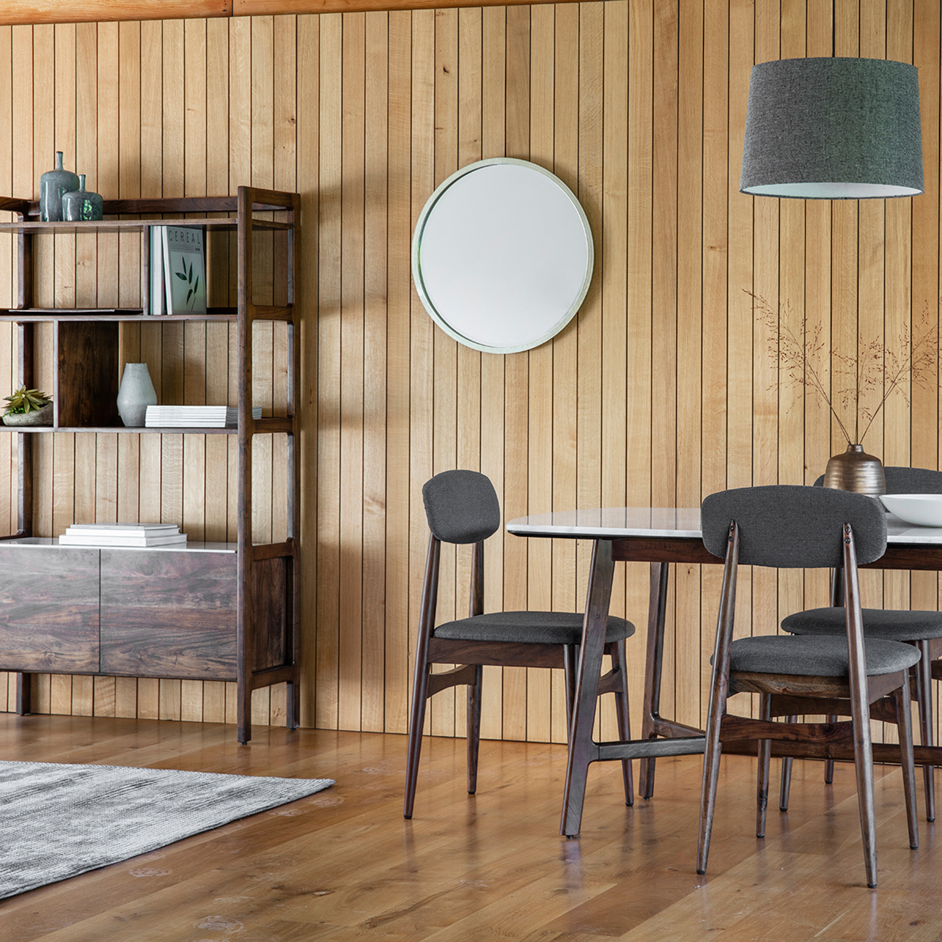 A room with different wood tones on the walls, floors, shelves, tables and chairs